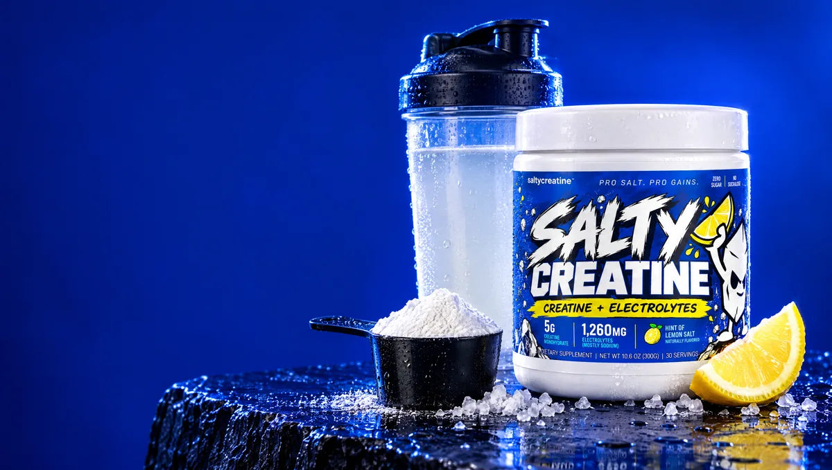 Salty Creatine tub with a scoop of powder, a shaker and a lemon wedge